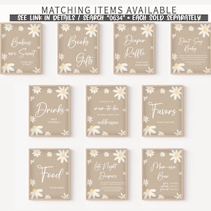 Op de afbeelding: Een verzameling ingelijste borden met madeliefjesaccenten en tekst voor een babyshower. Borden met opschriften als "Babies are Sweet", "Books & Gifts", "Diaper Raffle", "Don't Say Baby", "Drinks", "Favors", "Food", "Late Night Diapers" en "Mom-osa Bar".