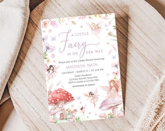 May include: A baby shower invitation with a whimsical fairy theme. The invitation features a watercolor illustration of fairies, mushrooms, and flowers. The text reads "A Little Fairy is on Her Way" and includes the details for the shower, including the date, time, and location.