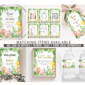 May include: A set of printable baby shower decorations featuring a jungle theme with dinosaurs, leaves, and a gold glitter font. The set includes a welcome sign, a don't say baby sign, water bottle labels, a thank you tag, and several game cards.