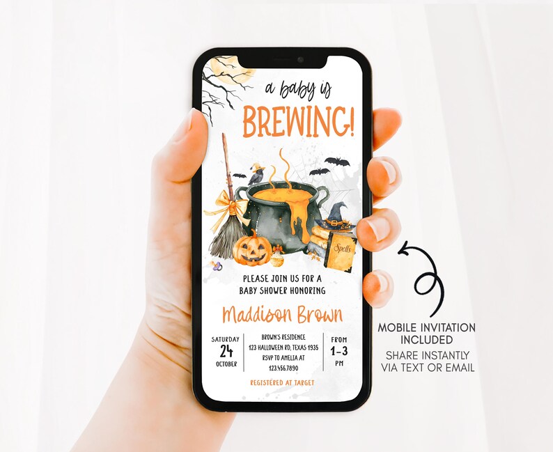 A hand holding a smartphone displaying an invitation for a baby shower.