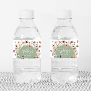 two water bottles with labels on them sitting on a table