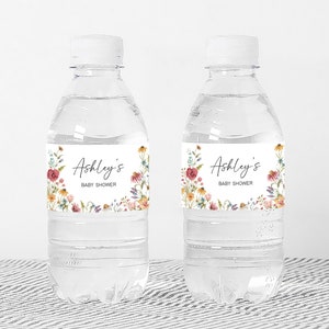 two water bottles with labels on them sitting on a table