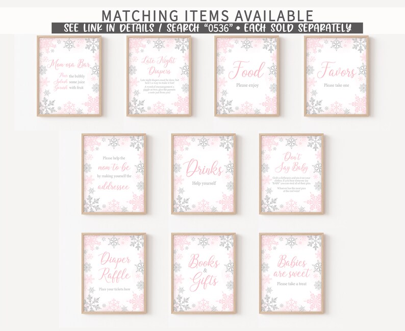 K&ouml;nnte beinhalten: Eine Sammlung von gerahmten Schildern mit rosa und silbernen Schneeflocken-Designs. Die Schilder tragen Texte wie "Mom osa Bar", "Food", "Favors", "Drinks" und "Babies are sweet". Die Schilder sind f&uuml;r eine Babyparty.
