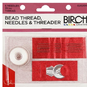 May include: A clear plastic pack containing a set of beading supplies. The set includes a spool of white thread, six needles, and a metal threader. The pack is labelled "Bead Thread, Needles & Threader" and "Birch Creative".