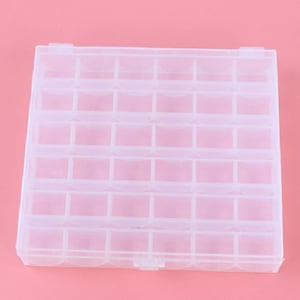 May include: A clear plastic storage box with 36 compartments. The box is designed for organising small items like beads, buttons, or jewellery.