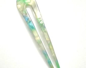 May include: A U-shaped hair fork with a pearlescent finish. The hair accessory features a blend of green, blue, and white hues. The hair pin is a decorative item for styling hair.
