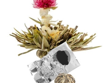 May include: A single blooming tea bud with a pink flower on top, surrounded by green leaves. The tea bud is packaged in a silver foil pouch.
