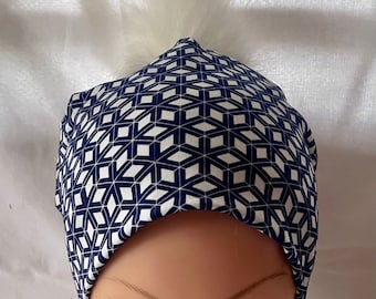 tuque/beanie/bonnet woman autumn winter jersey cotton lined background blue geometric pattern pompom white faux fur with snap button