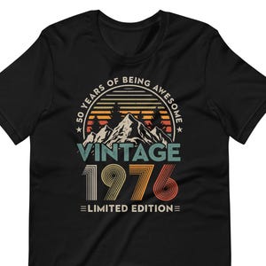 May include: Black t-shirt with a vintage design celebrating a 50th birthday. The graphic includes mountains, trees, and the text "50 Years of Being Awesome" and "Vintage 1976 Limited Edition" in retro colors.