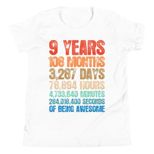 May include: White t-shirt with a colorful graphic that reads "9 Years 108 Months 3,287 Days 78,894 Hours 4,733,640 Minutes 284,018,400 Seconds of Being Awesome".