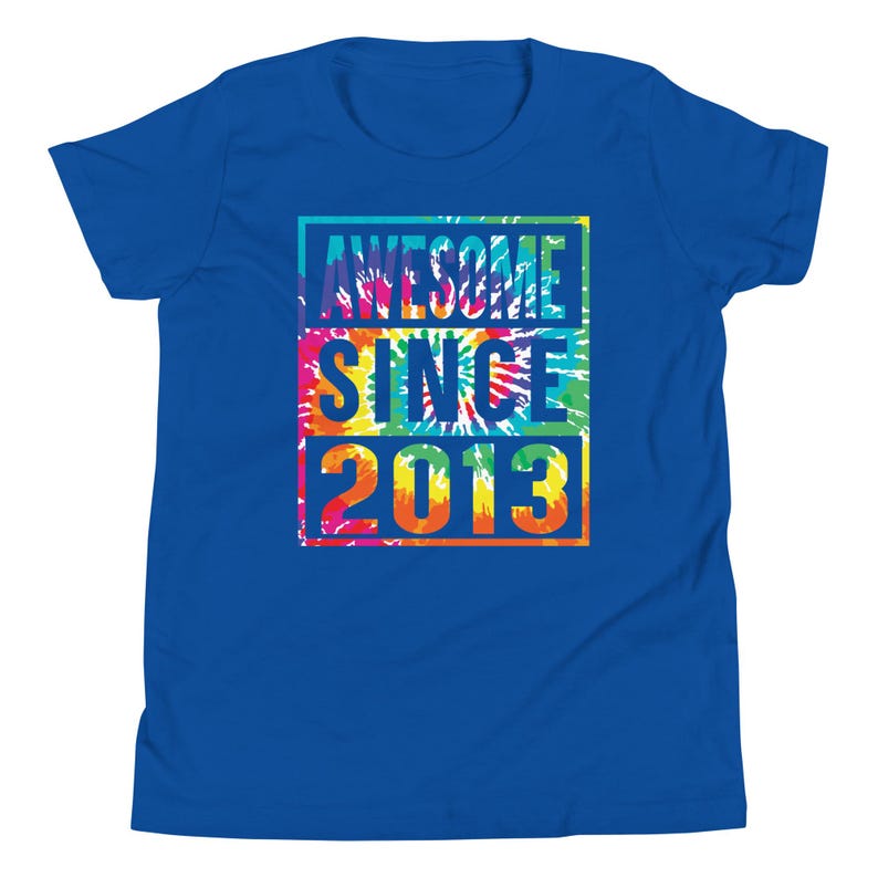 May include: A royal blue t-shirt featuring the text "AWESOME SINCE 2013" in a tie-dye design. The text is stacked in a rectangular shape. The shirt is made of a soft material and is suitable for casual wear.