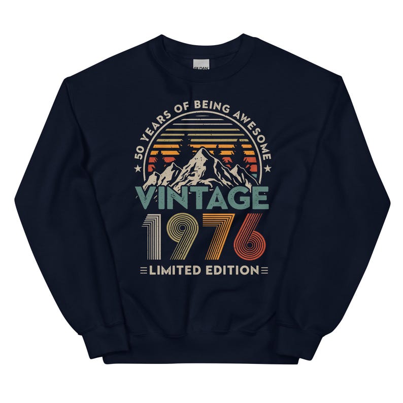May include: Navy blue sweatshirt with a vintage design. The graphic includes the text "50 YEARS OF BEING AWESOME" above "VINTAGE 1976 LIMITED EDITION" with a mountain and sunset scene.