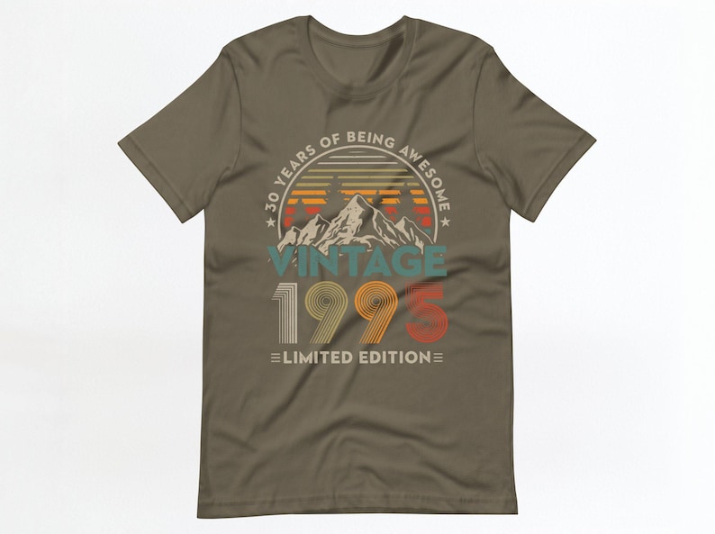 May include: A brown t-shirt with a vintage-style graphic that says "30 Years of Being Awesome Vintage 1995 Limited Edition". The graphic features a mountain range with a sunset behind it.