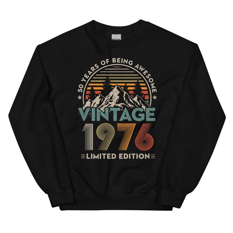 May include: Black sweatshirt with a vintage design. The graphic includes the text "50 YEARS OF BEING AWESOME" in a circular arc, with "VINTAGE 1976 LIMITED EDITION" below a mountain and tree illustration.