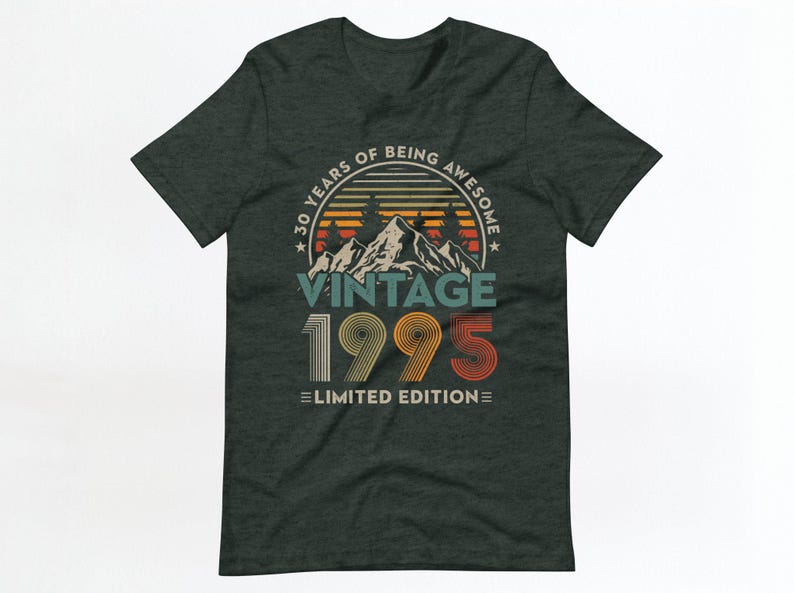 May include: A dark green t-shirt with a vintage-style graphic that says "30 Years of Being Awesome Vintage 1995 Limited Edition". The graphic features a mountain range with a sunset behind it.