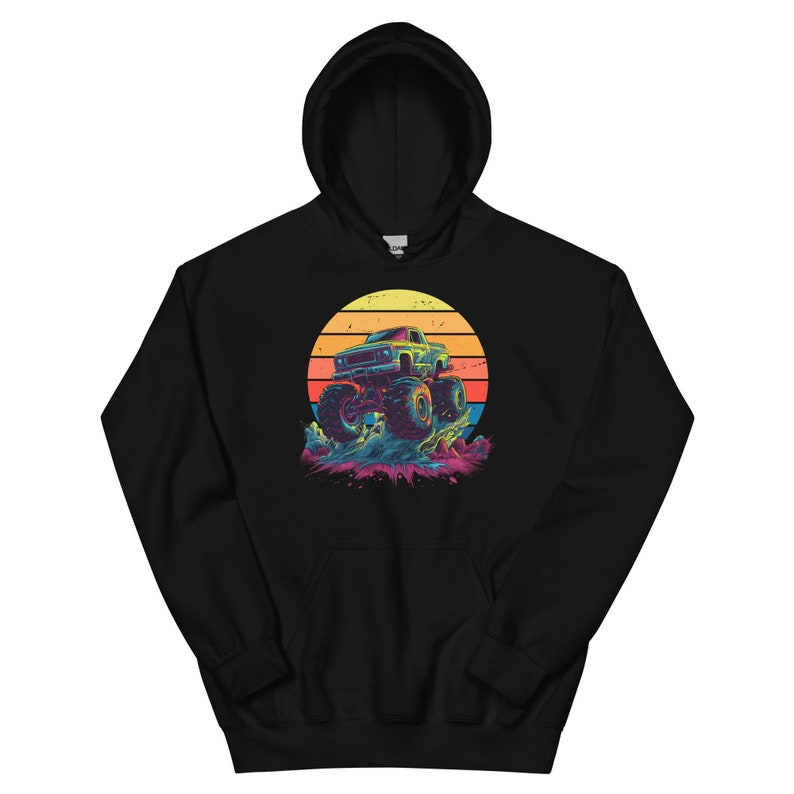 May include: Black hoodie with a graphic of a monster truck set against a sunset. The design features a large, stylised truck with oversized wheels, set against a vibrant orange, yellow, and red striped sun.
