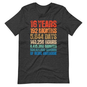 May include: A dark charcoal gray short-sleeve t-shirt featuring a multi-colored graphic print that reads: 16 YEARS, 192 MONTHS, 5,844 DAYS, 140,256 HOURS, 8,415,360 MINUTES, 504,921,600 SECONDS OF BEING AWESOME in a stacked, retro-style font.