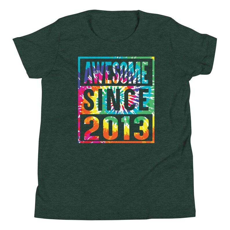 May include: Dark green t-shirt featuring the text "AWESOME SINCE 2013" in a vibrant tie-dye pattern. The text is within a rectangular frame. The shirt is made of a soft material.
