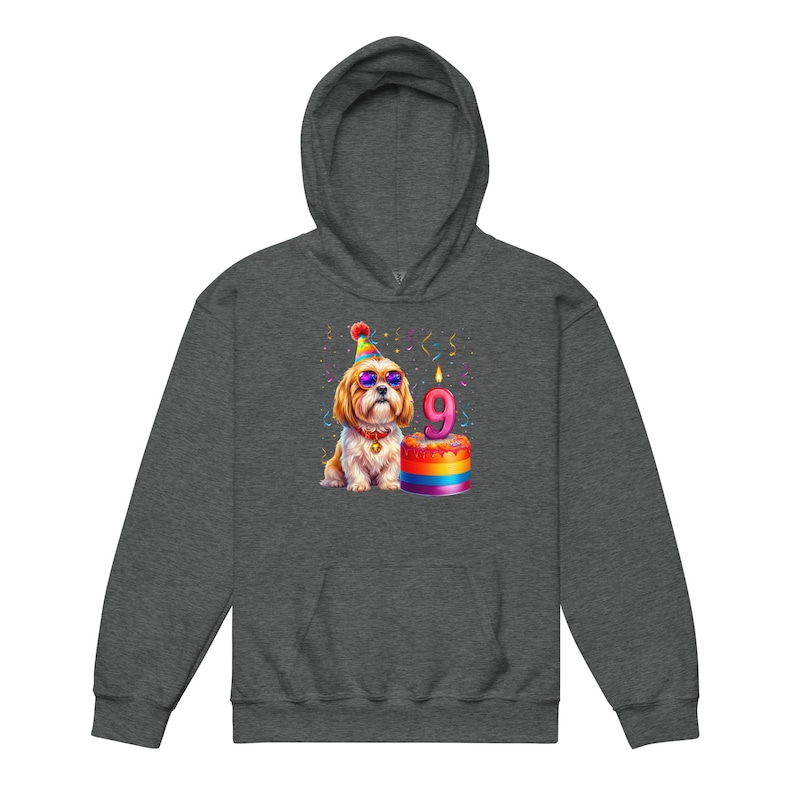 May include: Dark gray hoodie featuring a colorful illustration of a Shih Tzu wearing sunglasses and a party hat. The dog is next to a rainbow-colored cake with a lit candle that reads "9". Confetti is scattered around the image.