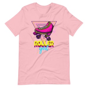 May include: Pale pink t-shirt with a retro roller skate design. The graphic includes a pink roller skate, a triangle, and the words "ROLLER girl" in a vibrant, 80s-style font. A stylish tee for roller skating fans.
