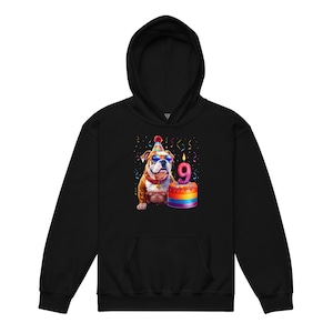 May include: Black hoodie featuring a colorful illustration of a bulldog wearing sunglasses and a party hat. The bulldog is next to a rainbow-colored cake with a lit candle displaying the number 9. Confetti and streamers are in the background.
