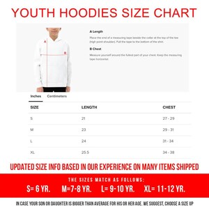May include: A white youth hoodie size chart with measurements in inches and centimeters. The chart includes length and chest measurements for sizes S, M, L, and XL. The text reads "UPDATED SIZE INFO BASED ON OUR EXPERIENCE ON MANY ITEMS SHIPPED."