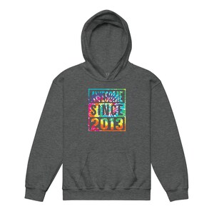 May include: A charcoal grey hoodie with a tie-dye design. The design features the words "AWESOME SINCE 2013" in a colourful, rectangular block.