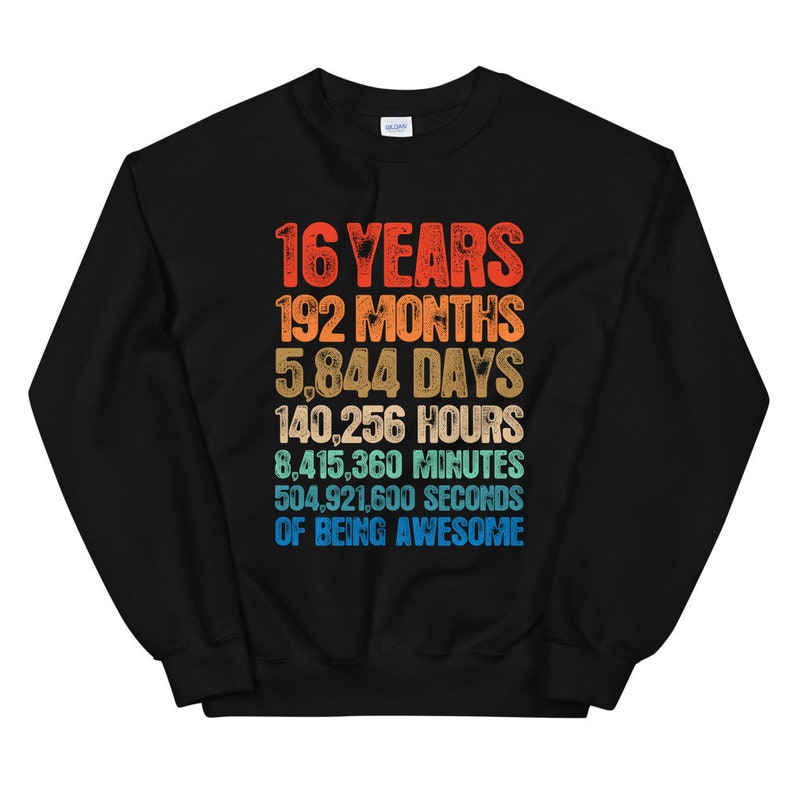 May include: A black crewneck sweatshirt featuring a multi-colored graphic print with the text: 16 YEARS, 192 MONTHS, 5,844 DAYS, 140,256 HOURS, 8,415,360 MINUTES, 504,921,600 SECONDS OF BEING AWESOME, displayed in a stacked, distressed font style.