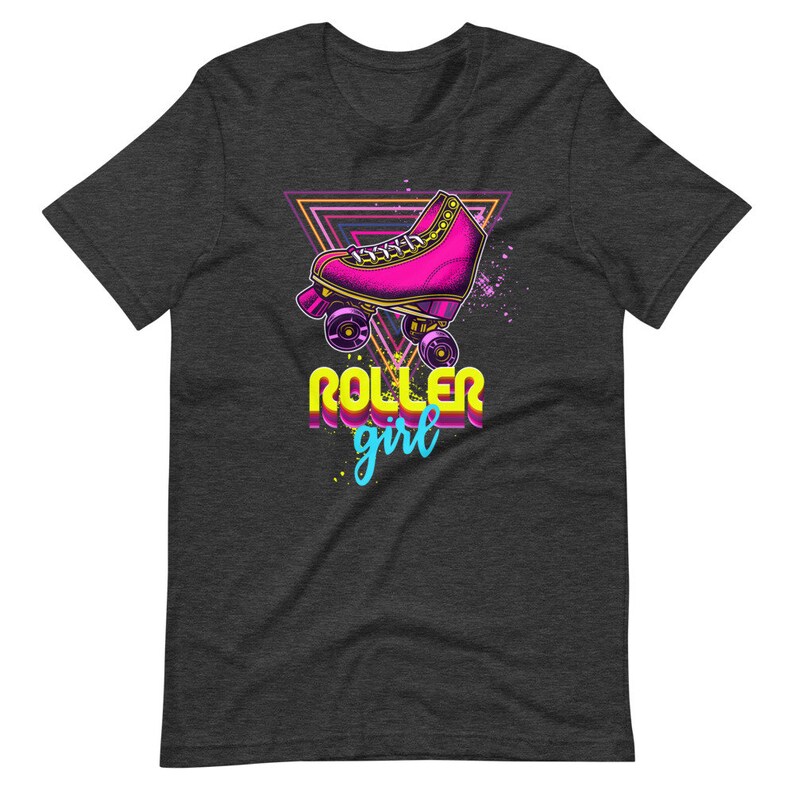 May include: Dark grey t-shirt with a graphic of a pink roller skate with purple wheels, set against a neon triangle. The words "ROLLER girl" are in a retro font, with a splash of blue and yellow.