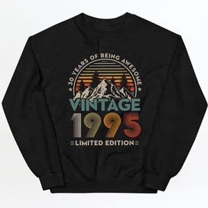 May include: Black sweatshirt with a vintage 1995 design. The text reads "30 Years of Being Awesome Vintage 1995 Limited Edition" with a mountain range and sunset graphic.