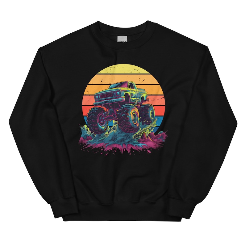May include: Black sweatshirt with a vibrant graphic of a monster truck leaping over a splash of water. The design includes a retro sunset. The truck is blue and yellow, with large tyres.