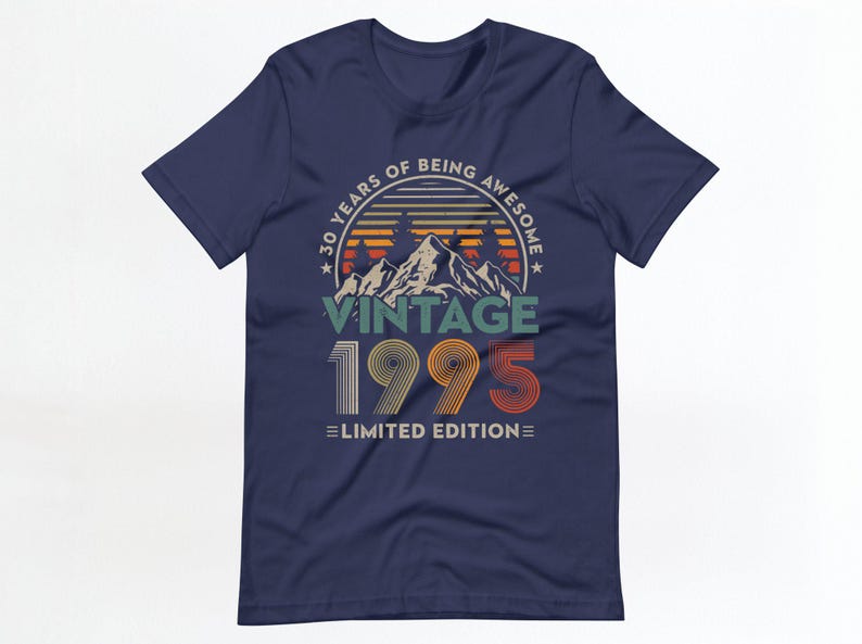 May include: Navy blue t-shirt with a vintage-style graphic design. The graphic features a mountain range with a sunset behind it and the text "30 Years of Being Awesome Vintage 1995 Limited Edition".