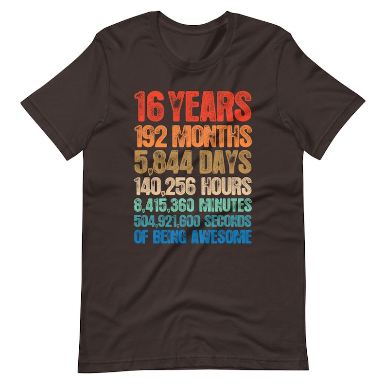 May include: A dark brown short-sleeve t-shirt featuring a multi-colored graphic with the text: 16 YEARS, 192 MONTHS, 5,844 DAYS, 140,256 HOURS, 8,415,360 MINUTES, 504,921,600 SECONDS OF BEING AWESOME, displayed in a stacked, retro-style font.