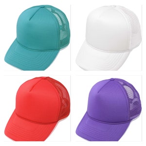 K&ouml;nnte beinhalten: Vier Trucker-Caps in verschiedenen Farben: Teal, Wei&szlig;, Rot und Lila. Jede Kappe hat eine einfarbige Frontplatte und eine Mesh-R&uuml;ckseite. Die Kappen haben einen gebogenen Schirm und einen Snapback-Verschluss.