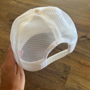 K&ouml;nnte beinhalten: Wei&szlig;e Trucker-Cap mit Mesh-R&uuml;ckseite und verstellbarem Schnappverschluss. Die Kappe hat eine durchgehende wei&szlig;e Front und einen gebogenen Schirm. Die Mesh-R&uuml;ckseite sorgt f&uuml;r Atmungsaktivit&auml;t.