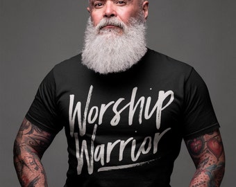 Puede incluir: Un hombre con una larga barba blanca lleva una camiseta negra con las palabras "Worship Warrior" impresas en blanco.