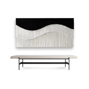May include: A large, rectangular wall hanging with a black upper section and a white, wavy lower section. Below, a long bench with a light-colored cushion and black metal legs. The artwork has a modern, minimalist aesthetic.