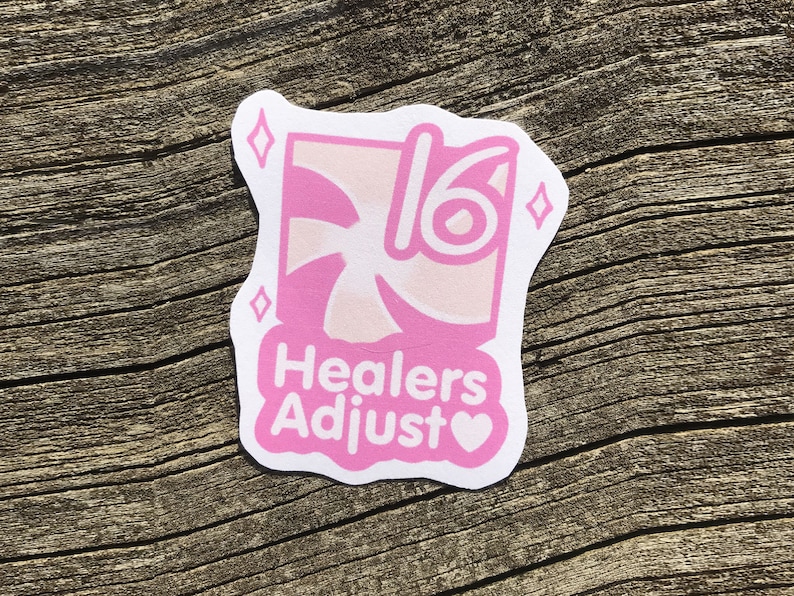 May include: Pink sticker with a swirl design and the text "Healers Adjust" with a heart symbol. The sticker also has a number "16" and two diamond shapes.