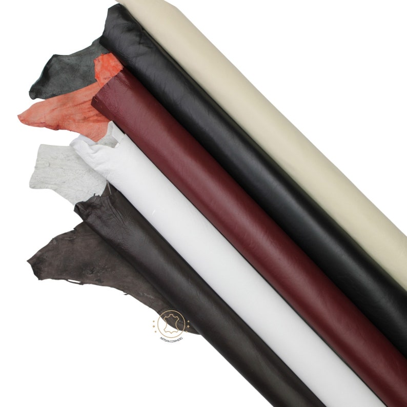 May include: Assortment of leather hides in various colors, including white, black, brown, red, and gray. The hides are rolled up and arranged in a fan shape.