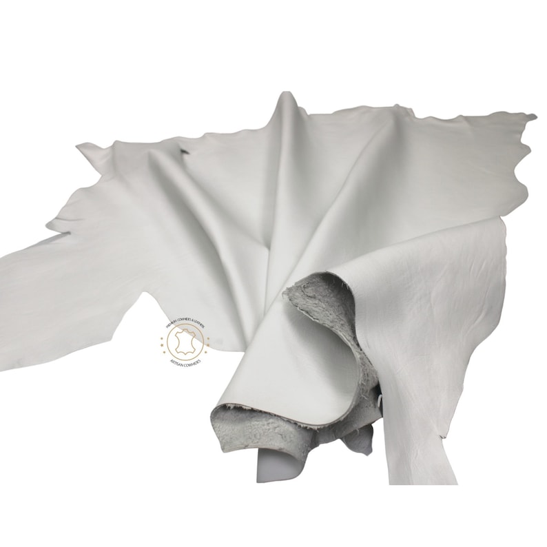 May include: A white leather hide, folded and displayed on a white background.