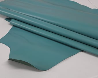 May include: A piece of teal blue leather folded on a white surface.