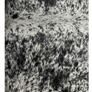 May include: Close-up of a black and white cowhide with a mottled pattern. The hide has a soft, natural texture.