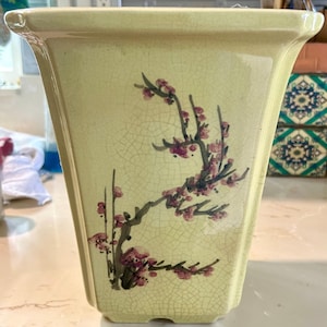 Antieke keramische vierkante bonsaipot in lichtgeel met handgeschilderde kersenbloesem aan de ene kant en Chinese karakters aan de andere kant. Craquelé, 28 cm hoog.