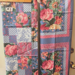 May include: Two rectangular fabric panels featuring a blue background with a multi-patterned design. The print includes large pink and yellow roses, green leaves, paisley motifs, and blue and white toile scenes, all arranged in a patchwork layout.