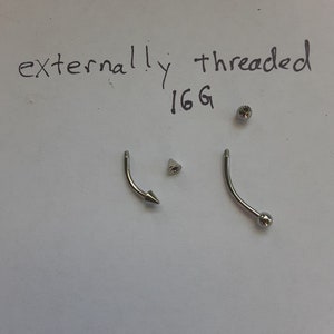 May include: Two silver externally threaded 16G body jewelry pieces. One piece has a ball end and the other has a pointed end.