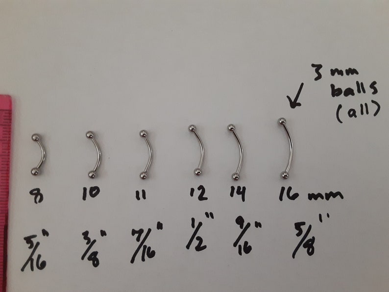 May include: A set of six curved barbell body jewelry pieces with 3 mm balls. The barbells are arranged in a row from smallest to largest, measuring 8 mm, 10 mm, 11 mm, 12 mm, 14 mm, and 16 mm. The measurements are written in millimeters and inches.