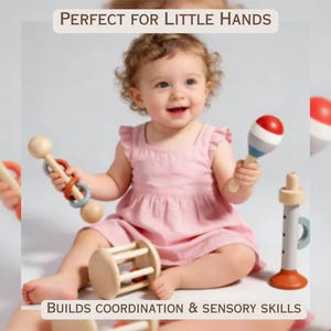 May include: A smiling baby in a pink dress surrounded by wooden toys. The toys include a rattle, a maraca, and a cylinder with a handle. The text at the top says "PERFECT FOR LITTLE HANDS". The text at the bottom says "BUILDS COORDINATION & SENSORY SKILLS".