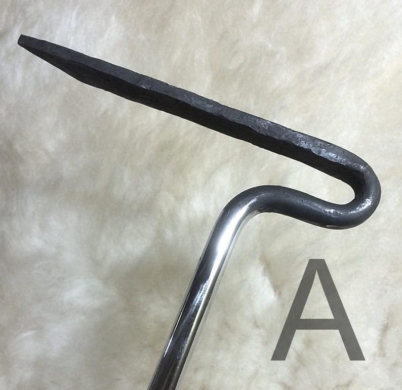 May include: A metal tool with a curved handle and a pointed, flattened end. The handle is polished, while the working end has a textured, dark finish. The letter "A" is visible in the image.
