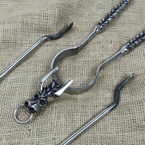 May include: A set of three metal fireplace tools with a dragon head design. The tools include a poker, tongs, and a brush.
