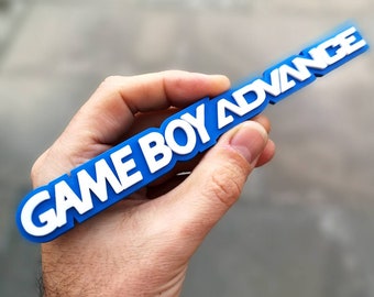 May include: A blue plastic keychain with the words "GAME BOY ADVANCE" in white letters.